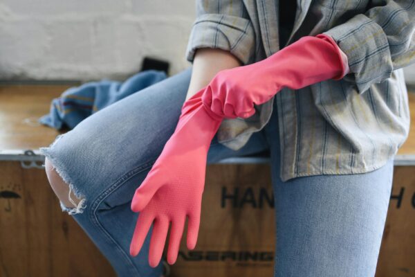 A Person Sitting on a Wooden Box Putting on Rubber Gloves