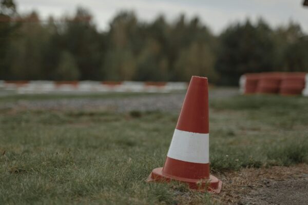 Orange and White Traffic Cone on Green Grass Field