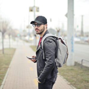 Man Wearing Black Leather Jacket Holding Smartphone